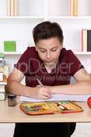 Kind beim Schreiben von Hausaufgaben in der Schule