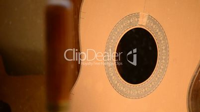 Close up of guitar in luthier workplace with wood shaving particles in the air