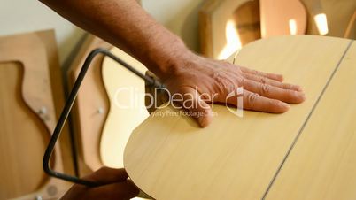 Luthier cuts wood with hacksaw, flamenco guitar