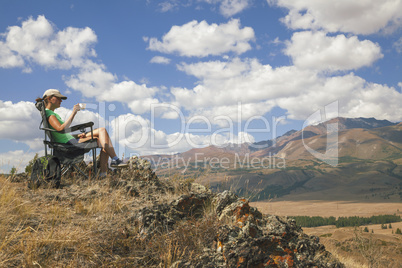 Happy tourist girl on the mountain