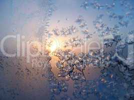 Ice pattern and sunlight on winter glass