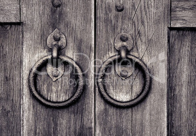 ancient wooden gate with door knocker rings