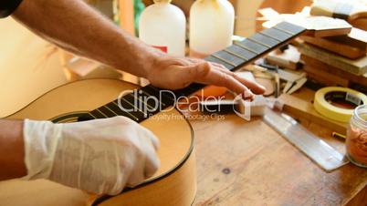 Luthier varnishing a guitar