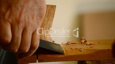 Luthier with chisel making a guitar mastil, close up