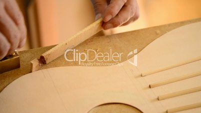 Luthier working in a guitar harmonic cover, close up