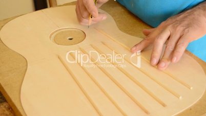 Luthier working in a guitar harmonic cover