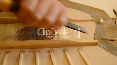 Luthier working with a chisel on a guitar