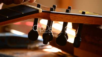 Luthier placing a string of a guitar