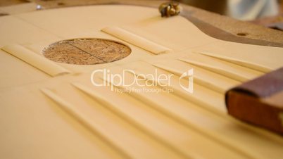 Luthier Sanding a guitar structure, close up