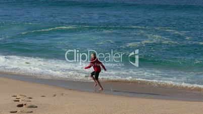 Woman Running on Beach with Waves in the Background