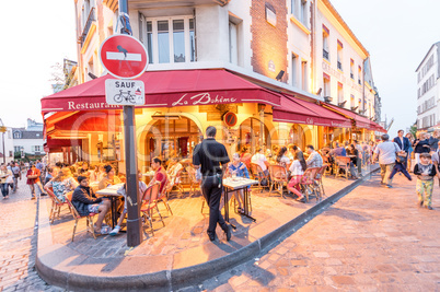 PARIS - JUNE 20, 2014: Tourists explore Montmartre streets at ni