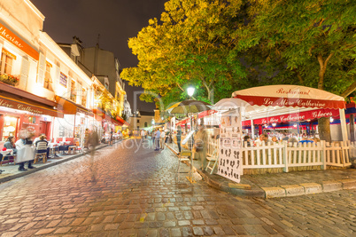 PARIS - JUNE 20, 2014: Tourists explore Montmartre streets at ni