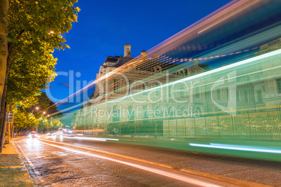 Car light trails across Paris avenues at night