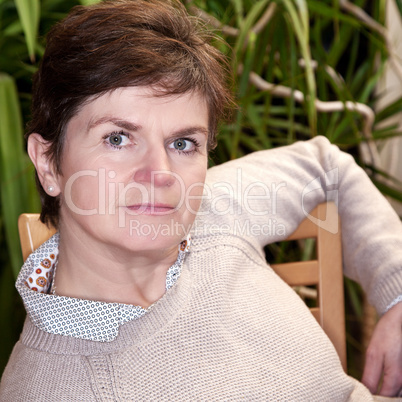 Casual woman sitting on the chair and smiling friendly