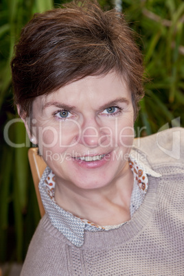 Casual woman sitting on the chair and smiling friendly