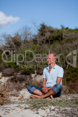 young man is relaxing outdoor in dune in summer