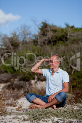 young man is relaxing outdoor in dune in summer