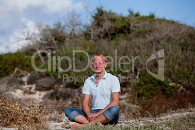 young man is relaxing outdoor in dune in summer