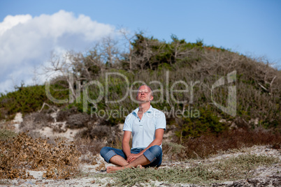 young man is relaxing outdoor in dune in summer