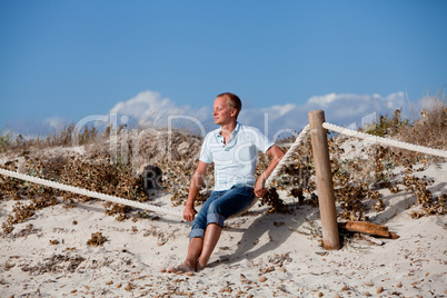 young man is relaxing outdoor in dune in summer