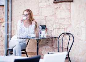 young woman is drinking coffee outdoor in summer