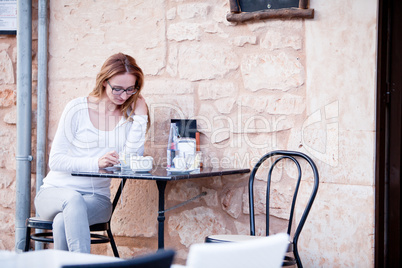 young woman is drinking coffee outdoor in summer