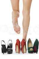 Woman Legs in Red Shoes Between Other High Heels