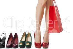 Woman Legs in Red Shoes Between Other High Heels