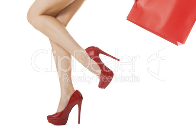 Woman Legs in Red High Heels Carrying Red Bag