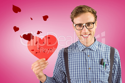 Composite image of geeky hipster holding a heart card