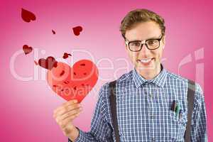 Composite image of geeky hipster holding a heart card