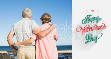 Composite image of happy casual couple looking out to sea