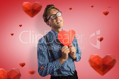 Composite image of geeky hipster covered in kisses