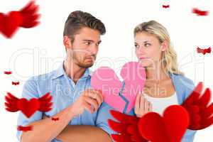 Composite image of couple holding two halves of broken heart