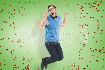 Composite image of geeky hipster jumping and smiling