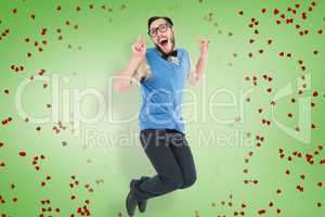 Composite image of geeky hipster jumping and smiling