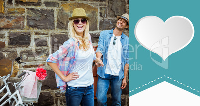 Composite image of hip young couple standing by brick wall with