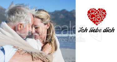 Composite image of smiling couple sitting on the beach under bla