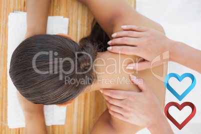 Composite image of beautiful brunette enjoying a shoulder massag