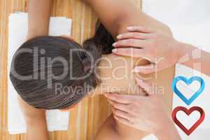 Composite image of beautiful brunette enjoying a shoulder massag