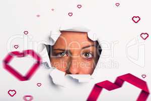 Composite image of young woman looking through paper rip