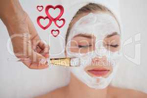 Composite image of beautiful blonde getting a facial treatment