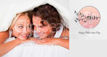 Composite image of couple under a duvet with a knowing smile