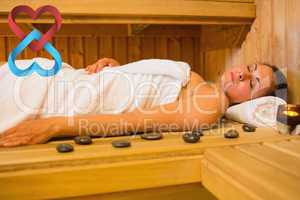 Composite image of peaceful brunette woman lying in a sauna