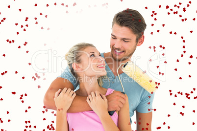 Composite image of young couple hugging and holding paint roller