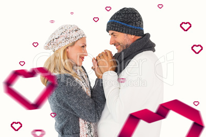 Composite image of couple in winter fashion embracing