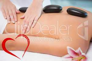 Composite image of beautiful woman receiving stone massage at he