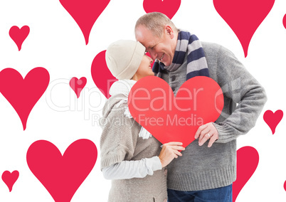 Composite image of happy mature couple in winter clothes holding