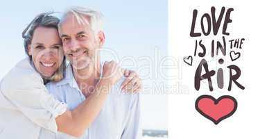 Composite image of attractive couple hugging at the beach smilin