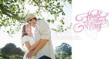 Composite image of cute couple standing in the park embracing